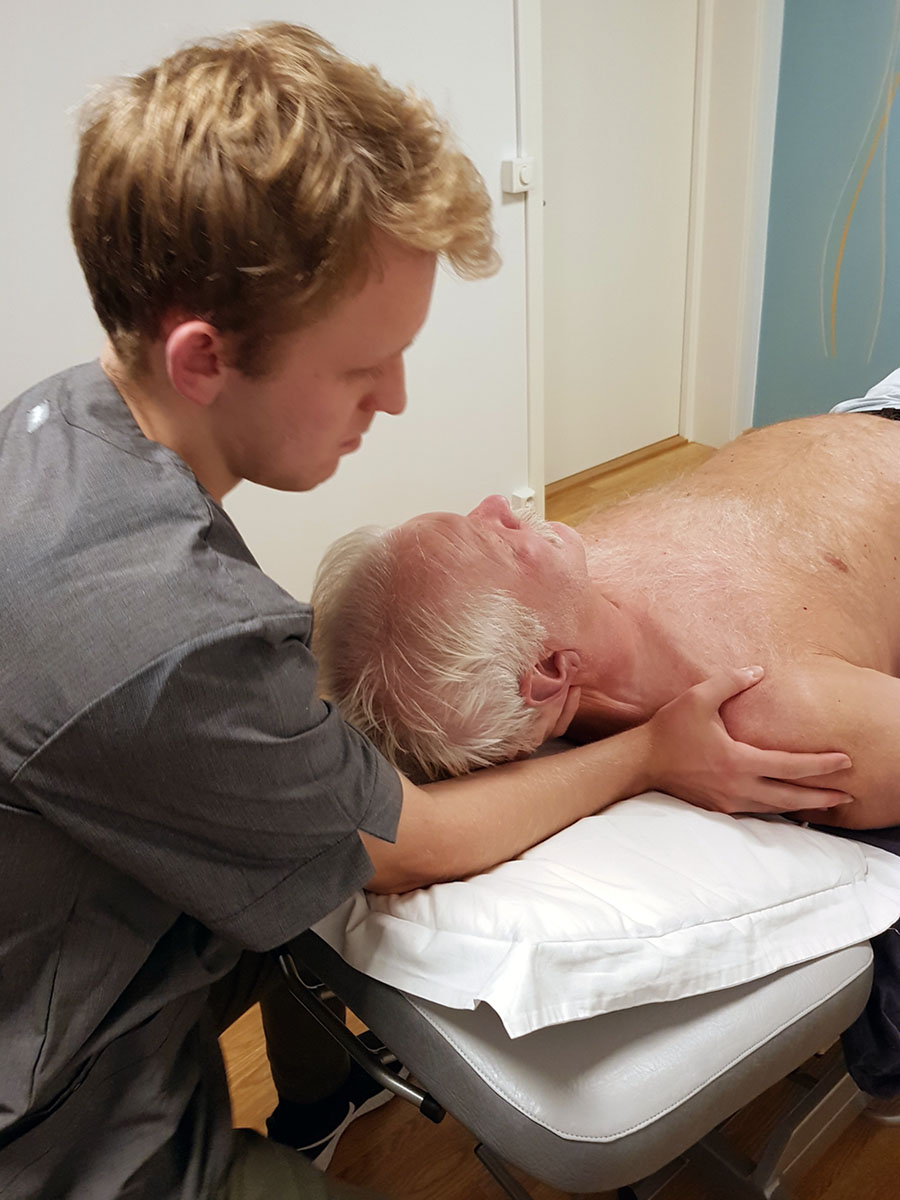 Osteopat Daniel tar et osteopat grep på pasientens skulder